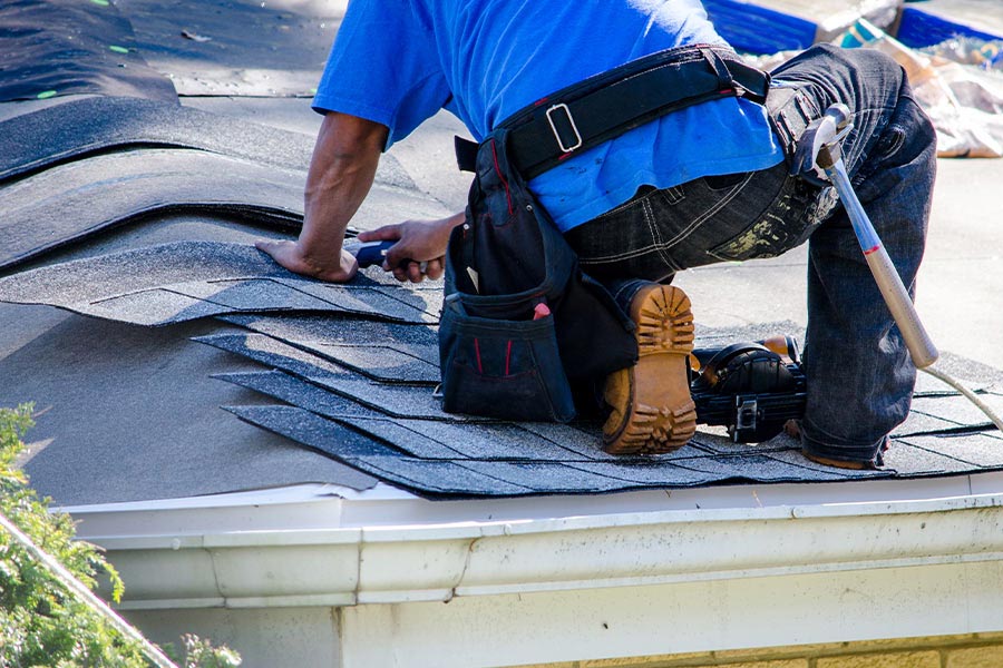 roofer repairing damaged shingles